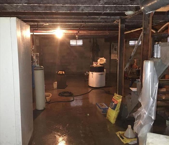 Basement with water damage and debris on the floor